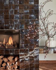 a fire place with logs and a vase