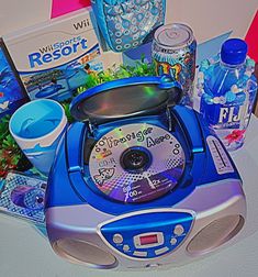 a blue and silver electronic device with various items around it on a white table top