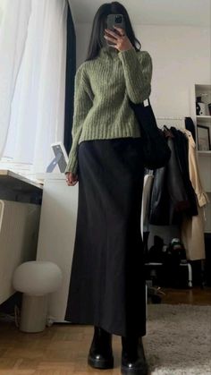 "The classic black long skirt and olive sweater is a timeless ensemble that you'll wear over and over again. With its modest but elegant vibe, this combination is a favorite among women for its versatility and versatility. It's perfect for a range of occasions, from formal events to casual days out, and can be styled in countless ways. The black skirt adds a touch of sophistication, while the olive sweater provides warmth and coziness. Ground Breaking Ceremony Outfit, Elegant Fits, 00s Mode, Black Skirt Outfits, Dream Fashion, Long Skirt Outfits, Future Wardrobe, Thrifted Outfits, 2024 Style