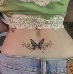 a woman with a butterfly tattoo on her lower back and the bottom part of her stomach