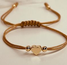 a bracelet with two gold hearts on it