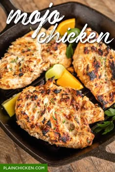 grilled chicken in a cast iron skillet with lemon wedges and parsley