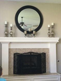 a fireplace with candles and a mirror above it