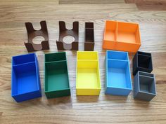 several different colored boxes sitting on top of a wooden floor