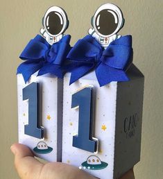 a person holding up two small blocks with the number one on them and an astronaut's face