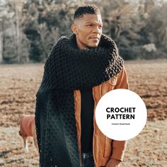 a man standing in a field wearing a black knitted scarf with the words crochet pattern on it