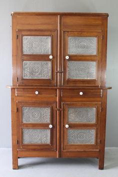 an old wooden cabinet with glass doors on the front and side panels inlays