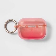 a pink case with a metal ring hanging from it's side on a white surface