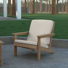 two wooden chairs sitting on top of a stone floor next to a grass covered field