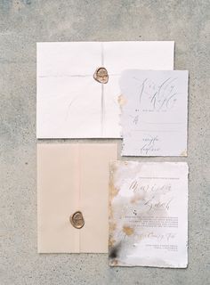 the wedding stationery is laid out on the concrete