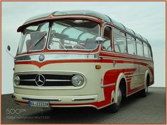 an old red and white bus is parked