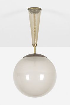 a white ball hanging from the ceiling with a gold metal cone on it's end