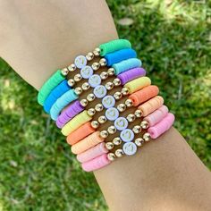 a woman's arm with several different colored bracelets on top of each other