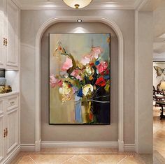 a painting is hanging on the wall in a room with white cabinets and beige walls