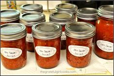 many jars filled with different kinds of food on a table together and labeled with labels