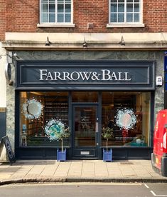 the storefront of farrow & ball is decorated with wreaths