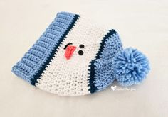 a crocheted snowman hat with a pom - pom on it