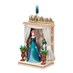 a christmas ornament with a woman in a blue dress standing on a stage