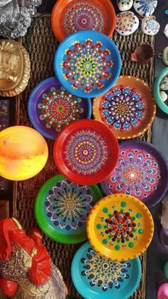 there are many colorful plates on the table