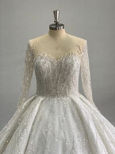 a white wedding dress with long sleeves and sequins on the bouncy