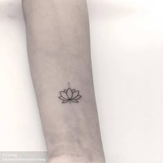 a small lotus tattoo on the wrist