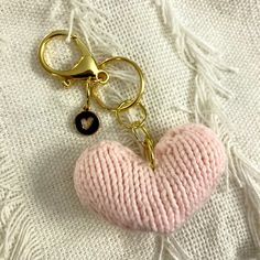 a pink heart shaped keychain with a black button