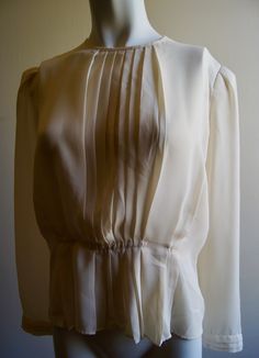 "Vintage handmade semi-sheer blouse. Great with ripped jeans and high heels! Pleated front. Pleated cuffs. Buttons at the back. Well made. Small elastic belt hidden inside. Small shoulder pads. No size tag Approximate measurements (Measured flat): Bust - 20\" Sleeve- 23.5\" Length (shoulder to hem) - 20.5\" Shoulder to shoulder across back- 14.5\" **bloclear-2" Classic Collared Blouse With Pleated Sleeves, Elegant Pleated Collared Blouse, Fall Button-up Blouse With Pleated Sleeves, Elegant Button-up Top With Pleated Sleeves, Classic Button-up Blouse With Pleated Sleeves, Pleated Blouse, Work Tops, Shoulder Pads, Ripped Jeans