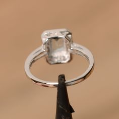 It is real natural aquamarine ring, the emerald cut aquamarine is about 5mm*7mm, weight about 0.86 carats. The basic metal is sterling silver and plated with rhodium. To change the metal to a solid gold (white/rose) or platinum is also available, please ask for a quotation if you want. You can also go to my shop Home for more elegant rings: https://www.etsy.com/shop/godjewelry?ref=hdr_shop_menu Aquamarine is the birthstone of January. More aquamarine rings: https://www.etsy.com/shop/godjewelry?r Formal Square Cut Silver Emerald Ring, Silver Emerald Ring With Asscher Cut Cubic Zirconia, Silver Topaz Ring With Rectangular Blue Stone, Emerald Cut Cubic Zirconia Topaz Ring With Halo Setting, Silver Blue Topaz Ring With Rectangular Stone, Emerald Cut Crystal Promise Ring With Halo Setting, Emerald Cut Crystal Ring With Halo Setting For Promise, Emerald Cut Crystal Ring With Halo Setting, Emerald-cut Topaz Ring With Halo Setting