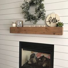 a fireplace with a wreath on top of it and some other decorations above the fire place