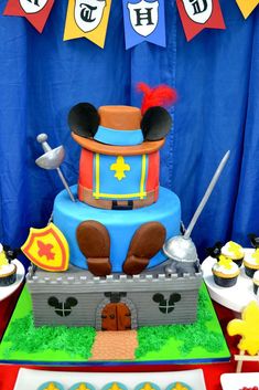 a mickey mouse birthday cake with cupcakes and decorations