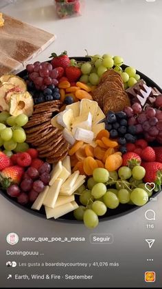 a platter full of cheese, fruit and crackers is displayed on instagram