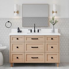 a bathroom vanity with two sinks and a large mirror over the top that hangs above it