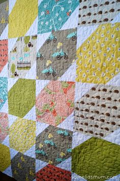 a quilt made with different colored squares and dots on it's sides, including the center