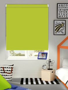 a bright green roller shade in a child's bedroom with black and white striped rug