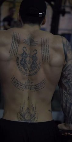 the back of a man with tattoos on his body