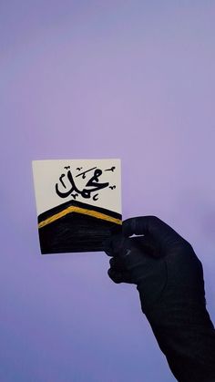 a hand holding up a business card with arabic writing