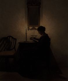 a woman sitting at a table in front of a candle