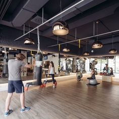 people in a gym doing exercises with exercise balls and punching gloves on the wall behind them