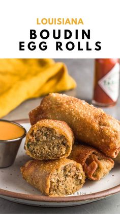 an egg roll on a plate next to a cup of sauce and a napkin with the words, louisiana boudin egg rolls