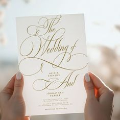 two hands holding up a wedding card with the word, the wedding i am written on it