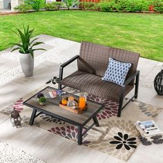 an outdoor patio with chairs, coffee table and potted plant