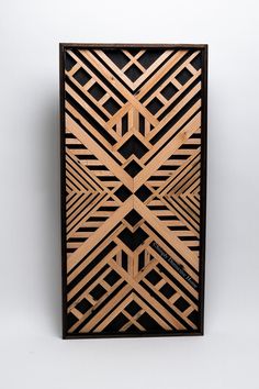 an art piece made out of wood on a white surface with black and brown lines