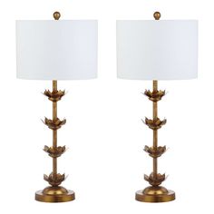 a pair of lamps with white shades on each lamp and one is gold leaf design