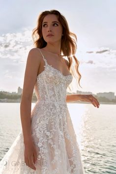 a woman in a white dress standing on the water