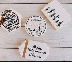 three clocks with words written on them sitting next to each other in front of a white wooden background