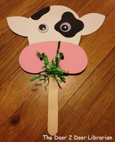 a paper cow on a stick with flowers