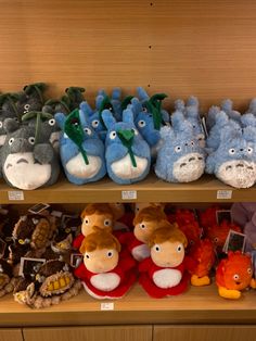 several stuffed animals are on display in a store shelf with other stuffed animals behind them