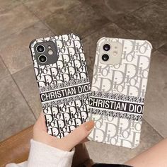 two cell phones with christian dior designs on them, one being held up by a woman's hand