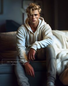 a man sitting on top of a couch wearing a white jacket and gray sweatpants