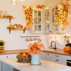 a kitchen with white cabinets and lights on the wall